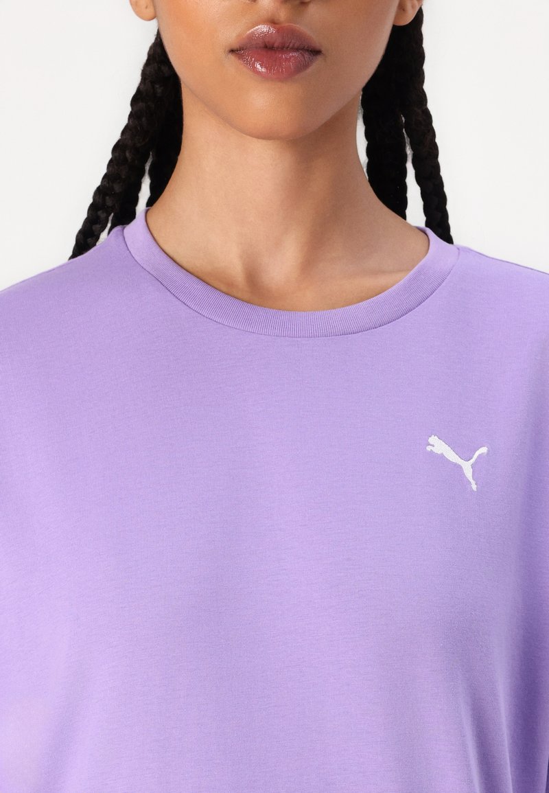Lila Baumwoll-T-Shirt mit Rundhalsausschnitt, mit einem weißen Puma-Logo auf der linken Brust. Glatte Textur, lockerer Schnitt.