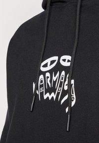 Black hoodie featuring a white graphic design of hands and letters on the chest. Includes black drawstrings and a soft texture.
