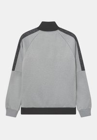 Felpa grigia con collo alto, maniche raglan e accenti neri sulle spalle. Presenta una texture liscia e polsini e orlo a costine.