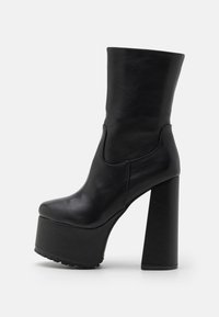 Bottes cheville en similicuir noir avec un talon bloc haut et une semelle plateforme. Présentent un design élégant et une texture lisse, avec un bout arrondi.