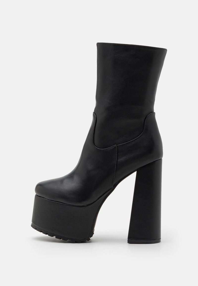 Bottes cheville en similicuir noir avec un talon bloc haut et une semelle plateforme. Présentent un design élégant et une texture lisse, avec un bout arrondi.