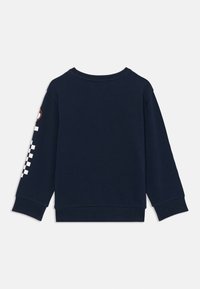Felpa blu navy con maniche lunghe, polsini a costine e scollatura rotonda. Presenta un motivo a scacchi e un patch circolare sulla manica.