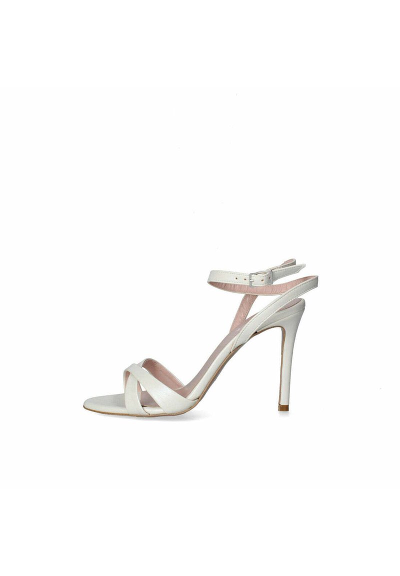 Sandalo stiletto bianco con design a cinturino incrociato, cinturino alla caviglia regolabile e tacco sottile. Finitura in pelle liscia con una leggera fodera rosa.