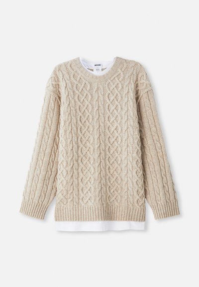 Beige gestrickter Pullover mit einem Zopfmuster, gerippten Bündchen und Saum. Lagenlook mit einem weißen Hemd, das am Saum sichtbar ist.