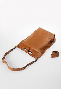 Borsa a tracolla in pelle color cammello, dotata di un design piatto, tracolla regolabile, accessori in metallo e una texture liscia con patta pieghevole.
