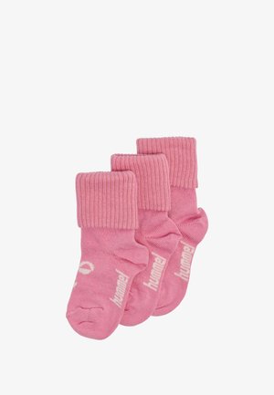 Trzy pary różowych skarpetek z prążkowanymi mankietami. Materiał jest miękki, o gładkiej fakturze. Każda skarpetka ma białe logo wzdłuż boku.
