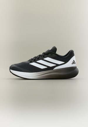 Czarno-biały but do biegania Adidas z trzema białymi paskami, siateczkową cholewką, amortyzowaną podeszwą i sznurowanym designem, widok z boku na neutralnym tle.
