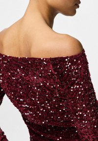 Bordeaux off-shoulder kjole med tekstureret pailletstof, der har et tætsiddende design og en glat, rund udskæring. Nærbillede set fra ryggen.