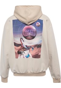 Beige hættetrøje med et stort grafiktryk på ryggen, der viser en skorpion og planeter mod en farverig kosmisk baggrund.