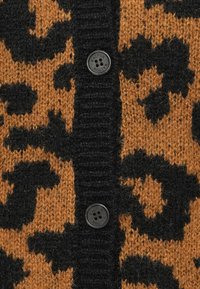 Cardigan imprimé léopard en orange et noir, avec un tricot texturé, un bouton noir et des détails côtelés le long des bords avant.