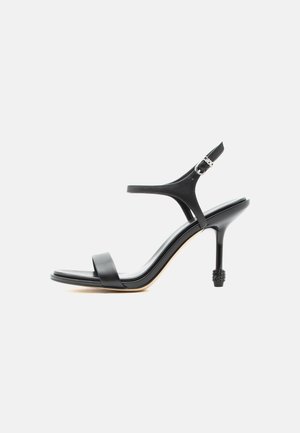 Čierna kožená sandála na vysokom opätku s tenkými remienkami, otvorenou špičkou a nastaviteľnou prackou na členku, zobrazená na jednoduchom bielom pozadí.