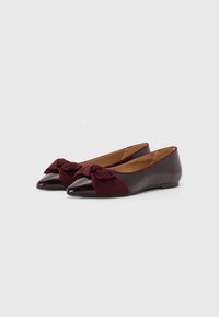 Ballerines bordeaux à bout pointu, dotées d'un accent en daim en forme de nœud sur le dessus et d'une finition brillante en verni. Talon bas et plat.