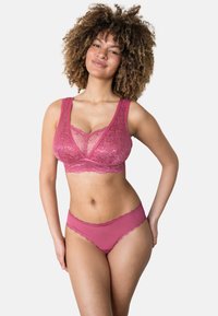 Spitzen-BH und passende Slips in einem tiefen Rosaton, aus weichem Material mit breiten Trägern und gewellten Kanten für zusätzliche Textur und Details im Design.