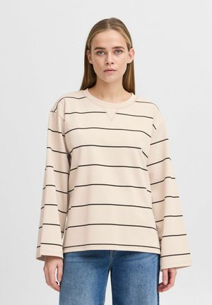 Top beige à manches longues avec des rayures horizontales noires, col rond et coupe décontractée. Le tissu semble doux avec une texture lisse.