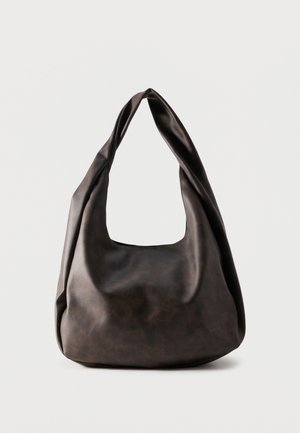 Mekana tamnosmeđa kožna torba hobo s jednim širokim remenom i opuštenim, nestrukturiranim oblikom na jednostavnoj pozadini.