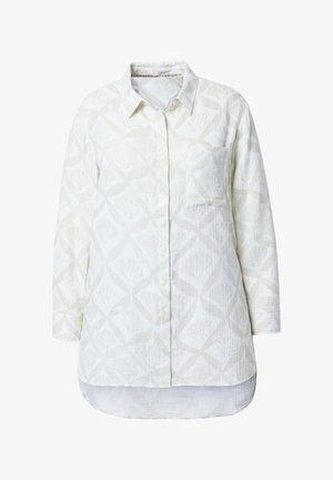 Hvid skjorte med knaplukning, der har et struktureret stof med et let, abstrakt muslingemønster. Inkluderer en brystlomme og en buet kant.