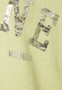 Světl zelený pletený svetr s texturovanými metalickými akcenty a prasklinami, s nápisem značky "MOS MOSH" v lesklém stříbře.