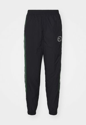 Černé sportovní kalhoty vyrobené z lehkého materiálu s zelenými bočními detaily a elastickým pasem, s malým bílým logem na levé straně.