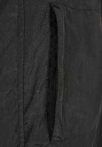 Juodas audinys švarkas su šonine kišene, švelni tekstūra, lygi apdaila ir minimalistinis dizainas. Nėra matomo hardware ar raštų.