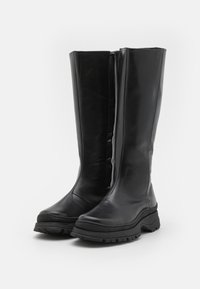 Čierne kožené čižmy po kolená vyrobené z hladkej kože s masívnou gumovou podrážkou a bočným zipsom pre jednoduché obúvanie. Vyznačujú sa elegantným dizajnom a okrúhlou špičkou.