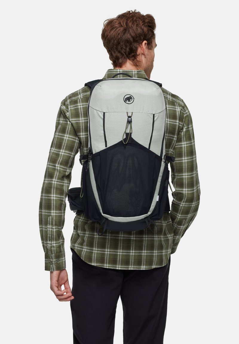 De rugzak heeft een grijs bovenstuk met een gestructureerd ontwerp, een zwarte mesh voorkant en verstelbare schouderbanden, geschikt voor buitenshuis gebruik.