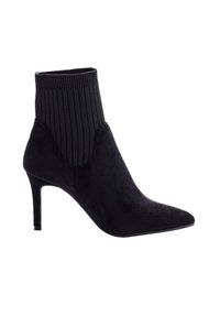 Stivale ankle in suede nero con punta affusolata, parte superiore a calza a costine e sottile tacco alto, vista laterale su sfondo bianco.