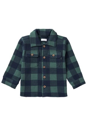 Chemise-veste à carreaux verts et bleu marine avec col, manches longues et deux poches poitrine à rabat avec bouton.