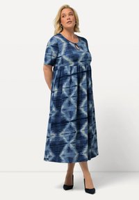 Maxiklänning i blå och krämfärgad batikmönster, korta ärmar, rundad halsringning med nyckelhålsdetalj och draperad midja.