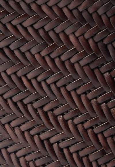 Sötétbarna, szőtt bőr, szoros geometrikus mintával. A textúra sima, enyhe fényével, amely a tervezés mesterségbeli tudását tükrözi.