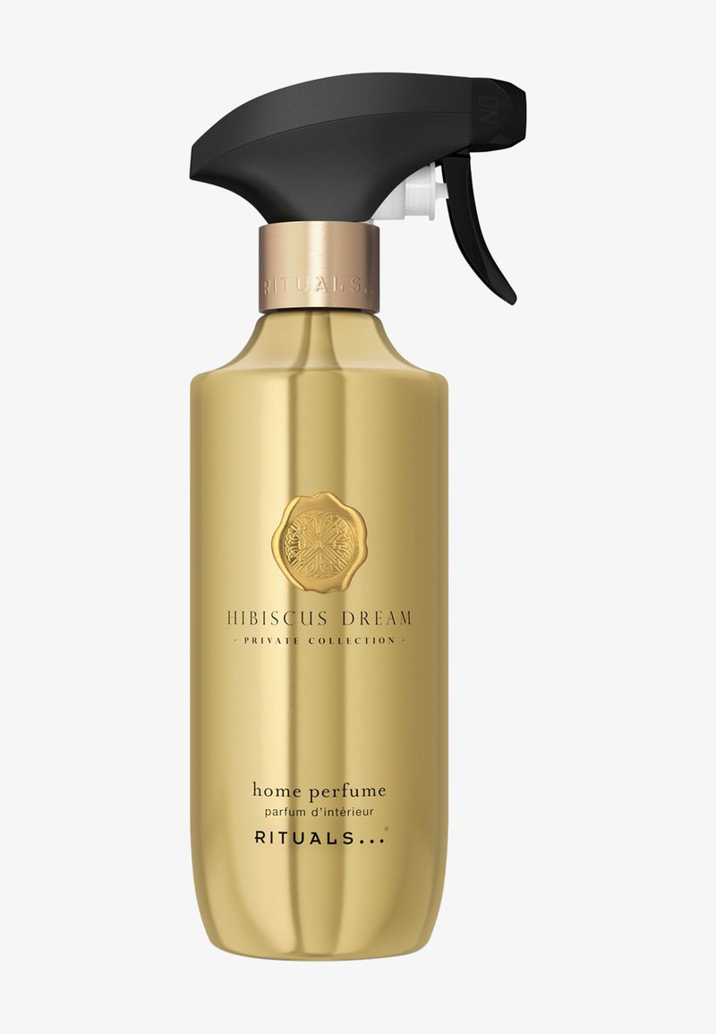 Gull sprayflaske for hjemmeparfyme med svart trigger og bronse detaljer. Har etikett med teksten "Hibiscus Dream" og teksturert sirkulært logodesign.