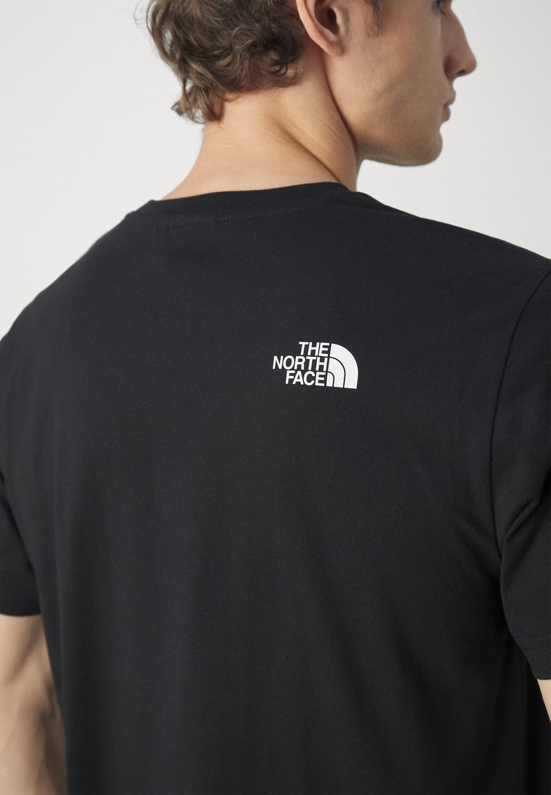 Black cotton t-shirt featuring a white logo print on the upper back. Short sleeves and a standard crew neck design. Smooth texture.