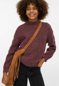 Granātādas krāsas adīts džemperis ar reljefām bumbiņām, augstu apkakli un garām piedurknēm; kopā ar brūnu velūru apvilktu plecu somu ar pušķiem.