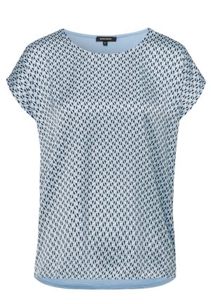 Blouse bleu clair à manches courtes avec un motif géométrique de petits triangles noirs et blancs et un col rond.