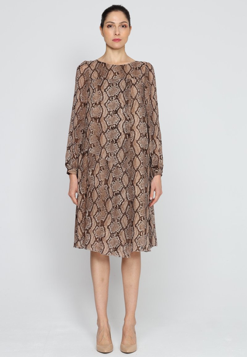 Brązowa sukienka w wężowy wzór z długim rękawem i okrągłym dekoltem. Miękka tkanina, lekko rozkloszowany dół i mankiety przy nadgarstkach.