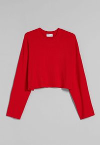 Czerwony prążkowany krótki sweter z długim rękawem, okrągłym dekoltem i opuszczonymi ramionami na jednolitym szarym tle.