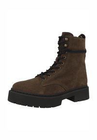 Bota de ante marrón con superficie texturizada, punta redonda, cordones negros y suela gruesa negra. Cuenta con ojales de latón y una lengüeta en la parte trasera.