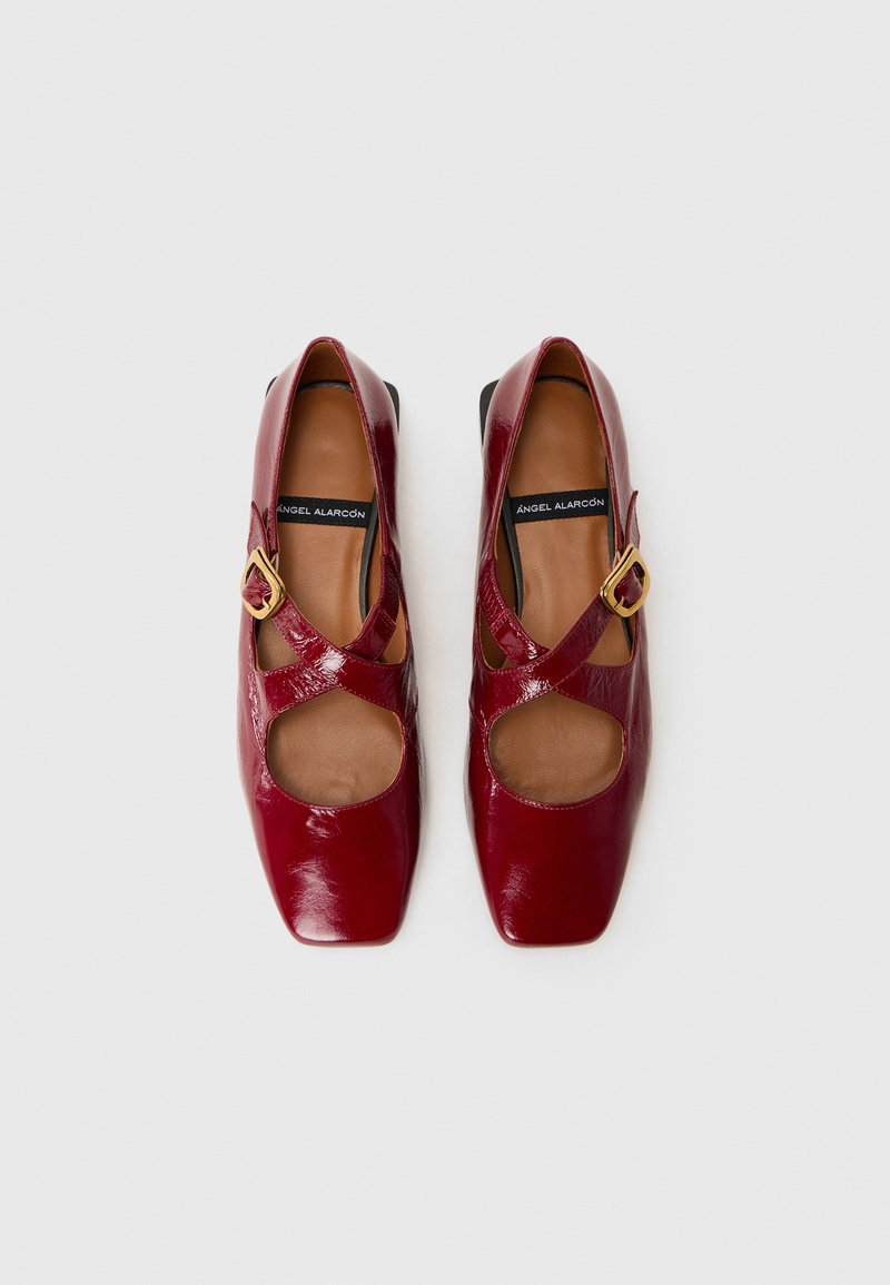 Scarpe in pelle verniciata rossa con cinturini incrociati e sezioni ritagliate. Design con punta quadrata e tacco solido basso, con dettaglio della fibbia in tonalità oro.