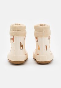 Bottes imperméables pour enfants avec un fond beige, ornées d'impressions animalières colorées. Col en tissu doux et semelle en caoutchouc pour une meilleure adhérence.