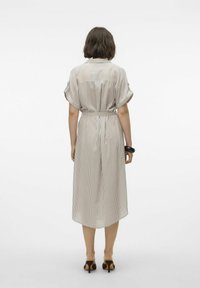 Abito midi a righe in tessuto leggero, con cintura in vita. Presenta un colletto e maniche corte arrotolate. L'orlo è più lungo sul retro.