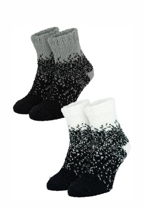 Zwei Paar Knöchelsocken: eine in Grau, das zu Schwarz verblasst, die andere in Weiß, das zu Schwarz verblasst, mit einem weichen, strukturierten Stoff.