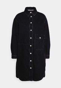 Svart denimskjortklänning med krage, knappfront och en bröstficka. Har en avslappnad passform och vita söms detaljer.