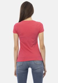 Chemise rouge à manches courtes en coton doux, au design ajusté, texture lisse, avec un col rond et sans motifs ni accents visibles.