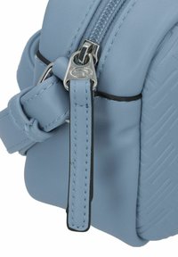 Hellblaues Lederhandtasche mit strukturiertem Design, silbernen Reißverschlussbeschlägen und einem geschlungenen Riemen für einen sicheren Halt.