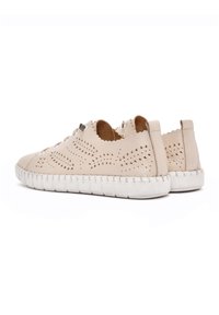 Sneakers in pelle beige con design perforato, suola in gomma bianca, punta arrotondata e dettagli ondulati sul retro. Passanti per i lacci imbottiti.