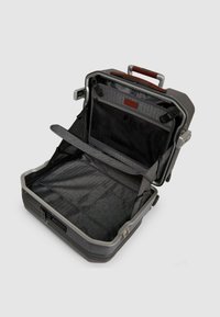 Harde koffer in donkergrijs met een gestructureerde afwerking. De binnenkant heeft een grijze stoffen voering, een gaaspocket en verstelbare riemen voor spullen.