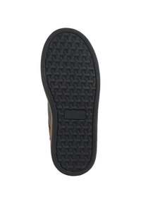 Semelle en caoutchouc avec une surface texturée présentant un motif noir de formes entrelacées et une découpe rectangulaire centrale pour la stabilité.