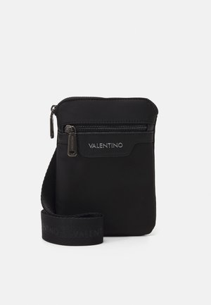 Borsa a spalla in nylon nero con tasca frontale con zip, tracolla regolabile e branding sottile. Texture liscia e design minimalista.