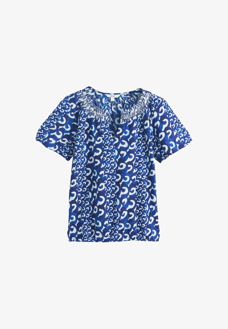 Blouse bleue à manches courtes avec motif abstrait blanc en spirale et encolure froncée smockée.