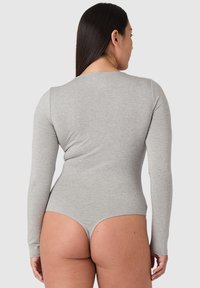 Šedý dlouhý rukáv bodysuit vyrobený z měkké, elastické látky, se hladkým povrchem a přiléhavým střihem s vysokým vykrojením na zádech.
