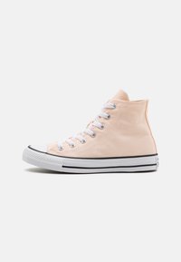 Høye sneakers i myk ferskenfarget kanvas, med hvite snøringer og gummikappe, sorte sidestriper og teksturert såle.